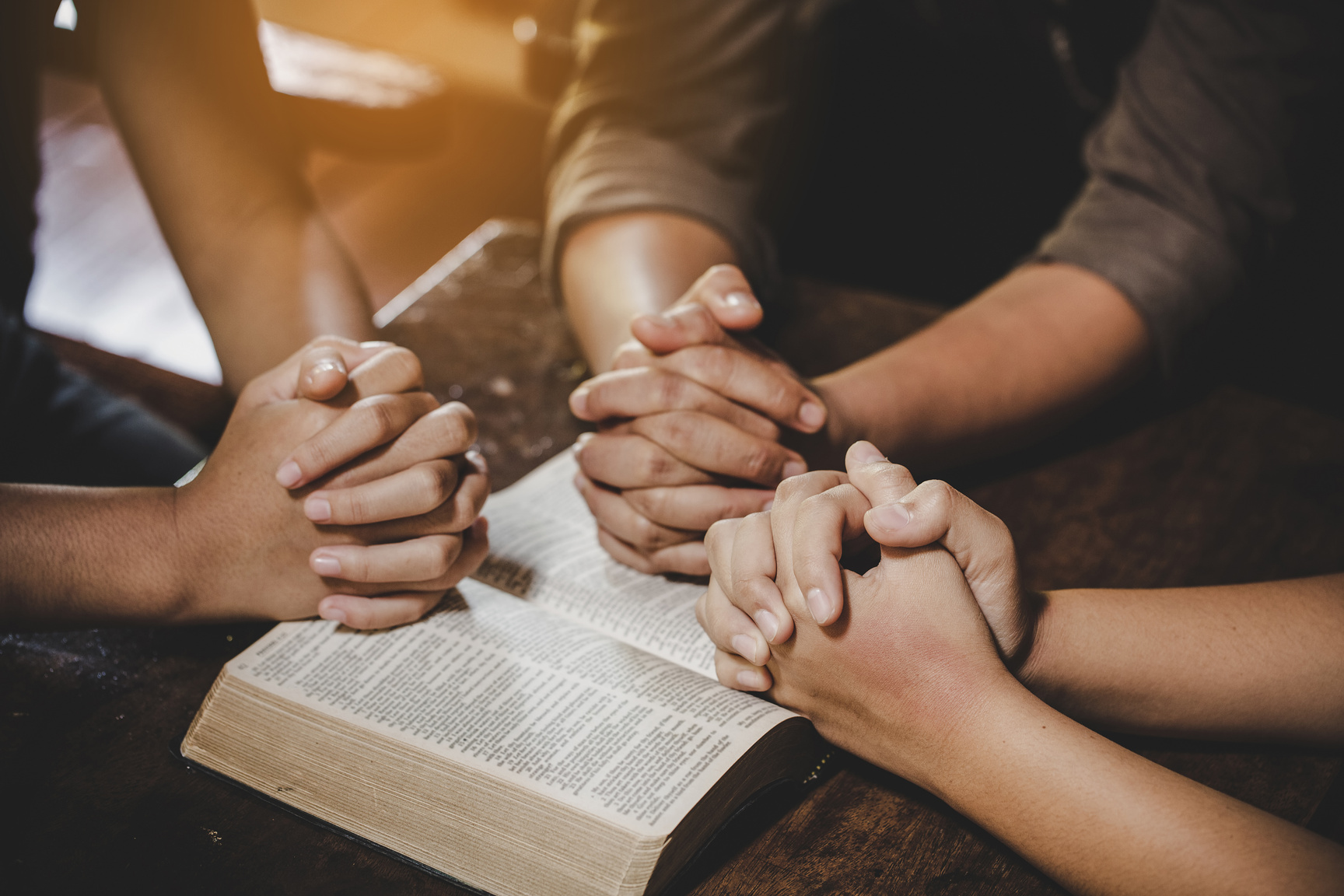 Group of People with Open Bible Praying Together
